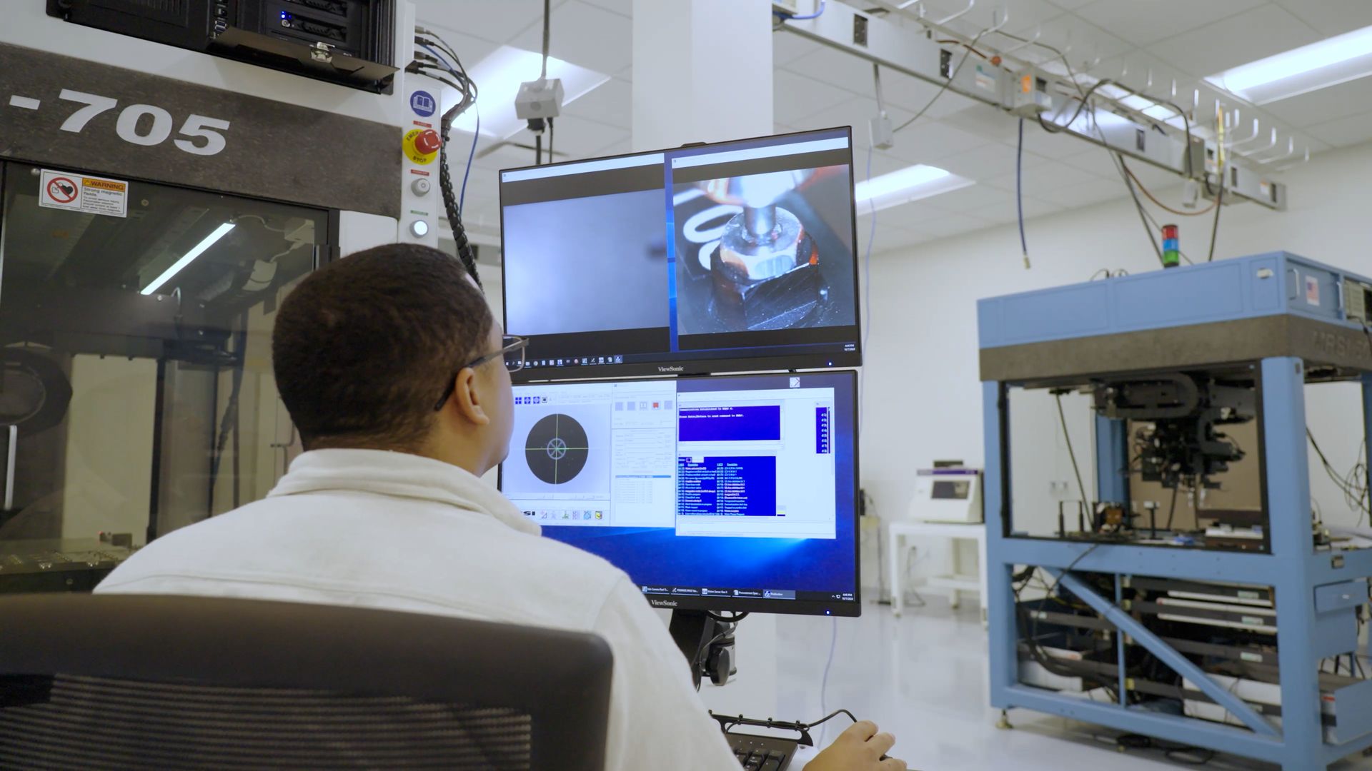 Miguel Burgos Jr, Service and Applications Engineer in front of a system